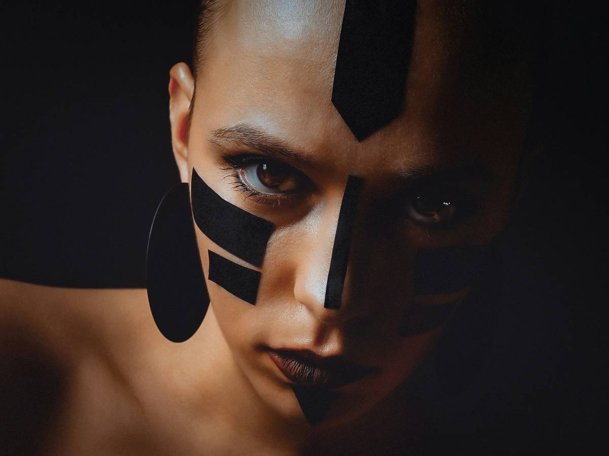 Close-up of theatrical makeup looks showcasing symbolic color blocking and textured skin effects for avant-garde runway presentation
